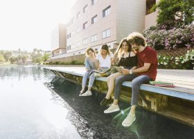 amigos-estudiando-cerca-del-edificio-con-lago-1