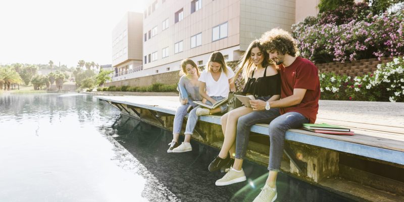 amigos-estudiando-cerca-del-edificio-con-lago-1